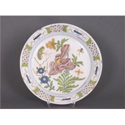 Teller. Fayence. Sandfarbener Scherben, weissglasiert. Der flache Spiegel farbig bemalt mit Blume...