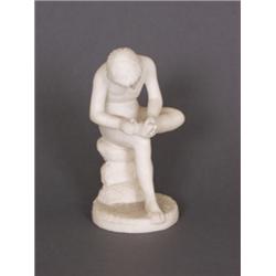 Porzellanfigur. Bisquitporzellan. Der Dornenzieher. Auf rundem Felssockel sitzender Jüngling beim...