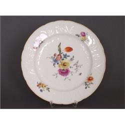 Teller. Reliefdekor Dulong. Im Spiegel polychrom gemaltes Blumenbukett und Streublumen. Goldrand....