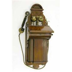 An early mahogany wall telephone, stamped L.M.Ericsson, with shaped case, twin bells and bakelite...