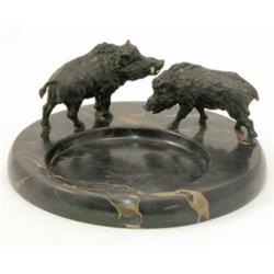 A bronze and marble ash-tray, mounted with two cast bronze boars behind dished centre, brown and...