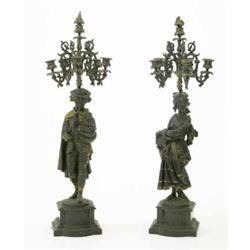 A pair of spelter five branch figural candelabrum, cast as a young boy playing the bagpipes and a...