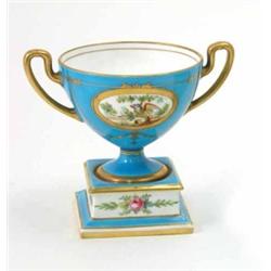 A blue Minton two handled porcelain cup, on square pedestal base decorated with two oval panels o...