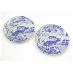 A pair of large Japanese blue and white porcelain wall plates, painted with carp, peonies and pru...