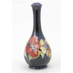 A Moorcroft Hibiscus lamp base, decorated with a tubelined design painted in shades of pink, yell...