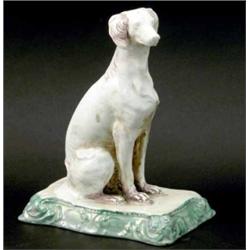 A late Victorian Mintons model of a seated dog, on rectangular base, moulded with scrolls, moulde...