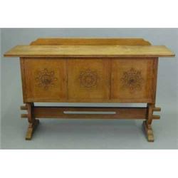 A Liberty & Co golden oak Arts & Crafts sideboard, with two cupboards and central panel carved wi...