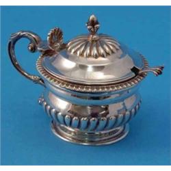 A George III silver drum mustard, with demi-fluted decoration, scroll handle, shell thumb-piece a...