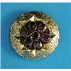 Image 1 : A Victorian circular gold brooch, set with a seven stone garnet flowerhead cluster, locket back...