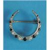 Image 1 : A 9ct gold crescent brooch, set with a graduated row of alternating sapphires and diamonds...