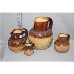 Four graduated Doulton Lambeth glazed pottery jugs including 7 1/2", 5", 4 1/4" and 2 3/4"all decora