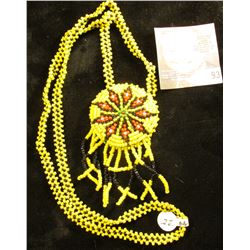 Necklace with pendant made from yellow, black, and red seed beads. 'Doc' valued it at $22.00.