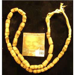 20" Strand of Old Indian Trade Beads, sand cast, strung on braided straw.