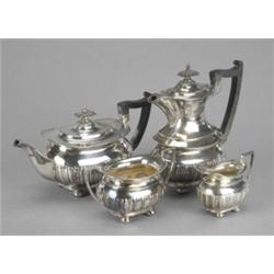 A four-piece tea service, of half lobed and fluted Regency boat form, on bun feet, angular handle...