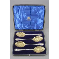 A set of four berry spoons, the gilt shell shaped bowls embossed with fruit and flowers, the stem...