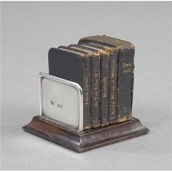 An Edwardian miniature silver mounted novelty bookstand, on stepped square wood base, containing...