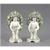 Image 1 : A pair of French 'Chelsea' figures of putti, each with a basket of flowers and wreath before blos...