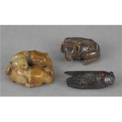 A patinated hardwood netsuke, carved as a resting water buffalo, 4.6cm; another, as a locust, 5cm...