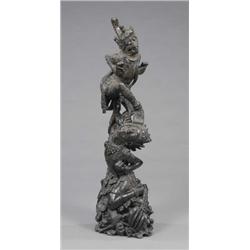 A large Burmese ebony carving of a monkey deity and temple dancer, on a rocky base, 47in high, mi...