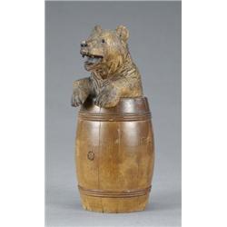 An amusing late 19th century Black Forest tobacco jar and cover, carved as a bear in a barrel, wi...