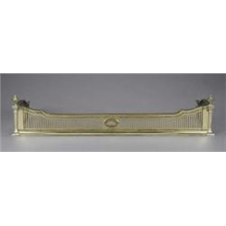An Edwardian brass Adam revival fender, the shaped sides pierced with paling centred with an oval...