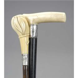 An ebony walking stick, with ivory handle and leaf chased silver mount; a malacca cane, with ivor...