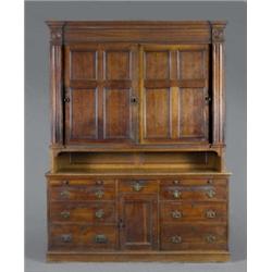 An early Victorian oak housekeepers cupboard, the pair of sliding moulded four-panel doors enclos...