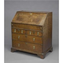 An early 18th century oak bureau, the fitted interior with a sliding well, the plain frieze with...