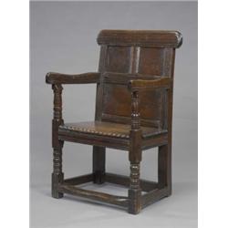 An oak armchair, with three-panel back, boarded seat, turned legs with stretchers (an old reconst...