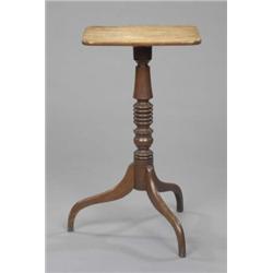 A George III oak torchere table, the rounded rectangular top on a turned pillar and arched tripod...