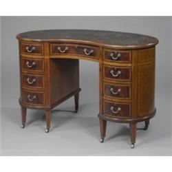 A late Victorian mahogany Sheraton revival kidney shaped pedestal desk, with inset stamped green...