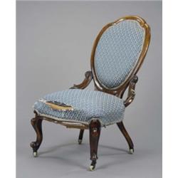 An early Victorian rosewood rococo revival nursing chair, the padded oval cameo back with pierced...