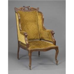 An unusual Victorian mahogany wingback armchair, in the French style, the brass nailed back, wing...