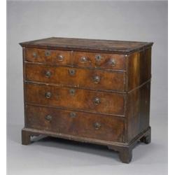 A George I walnut chest, fitted two short and three long drawers, with matched veneers and feathe...