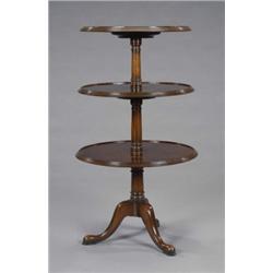 A mahogany dumb waiter, in George III style, the three circular tiers with raised moulded borders...