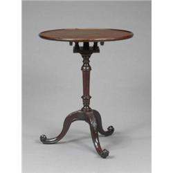 A fine George II mahogany occasional table, the circular top with raised moulded border tilting a...