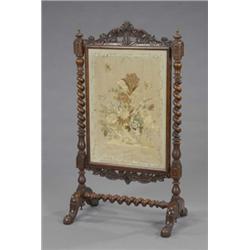 An early Victorian walnut firescreen, enclosing a rectangular silk needlework panel embroidered w...