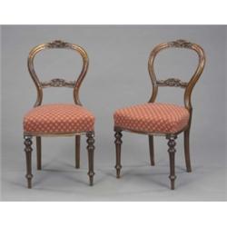 A set of six Victorian walnut side or dining chairs, the open balloon backs with leaf carved cres...