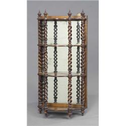 A set of Victorian walnut four-tier wall shelves, of serpentine mirror-back design, the open spir...