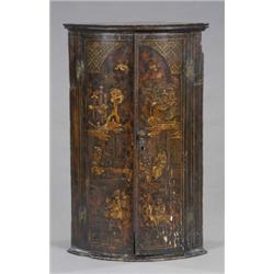 An early 18th century black japanned bow-front hanging corner cupboard, enclosed by a pair of doo...