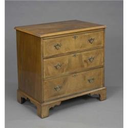 A compact walnut chest, in George I style, fitted three long drawers with matched veneers and cro...