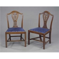 A set of four George III mahogany dining chairs, in Hepplewhite style, the fluted frames with arc...
