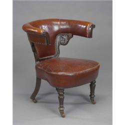 A substantial Victorian mahogany library chair, of bold semi-circular form, upholstered in brass...