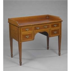 An Edwardian mahogany Sheraton revival kneehole dressing table, with three-quarter gallery above...