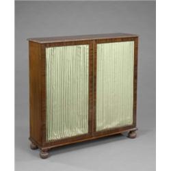 A Regency mahogany bookcase, the top with gadrooned border, enclosed by a pair of doors with gree...