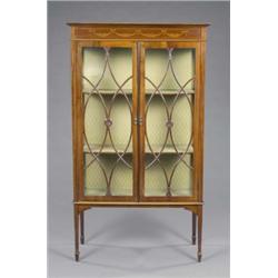An Edwardian mahogany Sheraton revival display cabinet, the green silk lined interior enclosed by...
