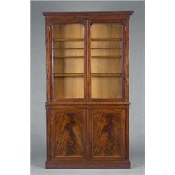 A Victorian mahogany bookcase-cabinet, the adjustable shelves enclosed by a pair of arched three-...