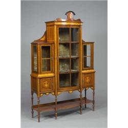 An Edwardian mahogany bow-centre display cabinet, the velvet lined interior enclosed by three doo...