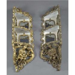 A decorative pair of early Victorian painted and gilt three-tier corner wall shelves, in rococo r...