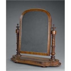 An early Victorian mahogany arched toilet mirror, on spirally fluted pillars, the curl veneered q...